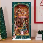 A festive DIY book nook kit featuring a Christmas-themed jingle cabin, complete with a snowman, gifts, a Christmas tree, and Santa sliding down the roof.
