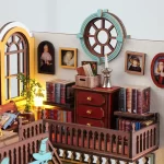 A close-up of a beautifully designed DIY miniature house featuring a classic European bookstore scene with vintage bookshelves, framed portraits, a wooden chest of drawers, and intricate architectural details.