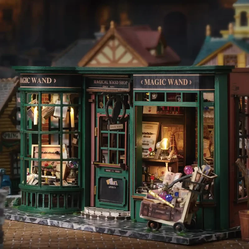 A detailed miniature of a magic wand shop with a green exterior, large windows, and a 