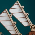 Close - up of light brown wooden sail - like components with white inserts on the Undersea Masterpiece 3D wooden puzzle, showing mechanical joints.