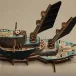 A finished 3D wooden puzzle of a mechanical ship, featuring light brown, teal, and black wooden parts, gears, and decorative cut - outs.