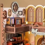 A detailed DIY miniature of a magic book store, showcasing bookshelves, framed pictures on the wall, a welcoming sign, and cozy lighting.