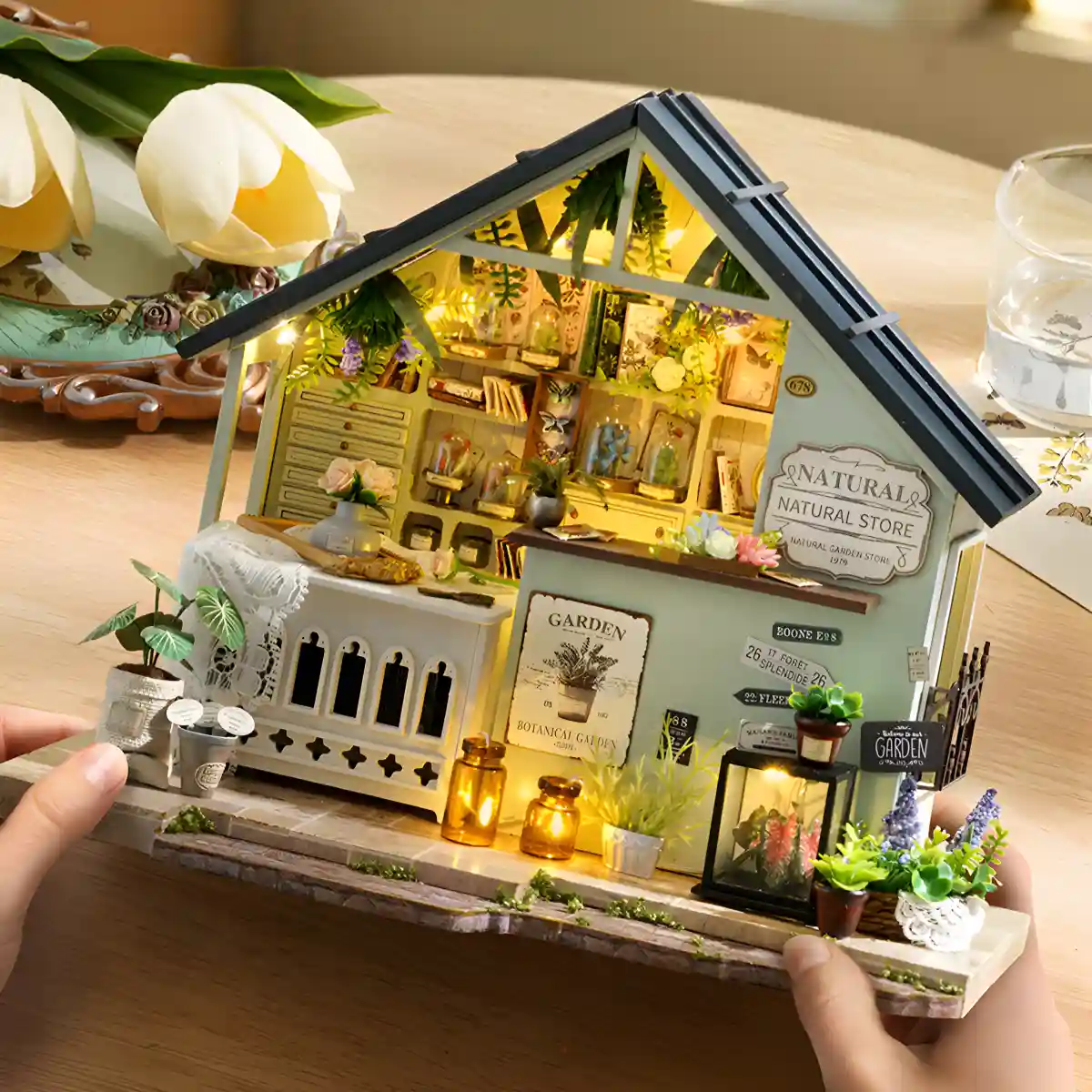 Hands holding the completed plant dollhouse, showing its overall structure and details.