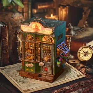 The fully assembled Magic Shop Book Nook Kit displayed on a desk with vintage books, a compass, and other antique-looking items.