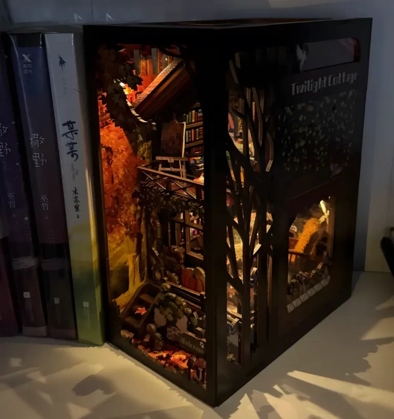 "Twilight Cottage" book nook illuminated on bookshelf.