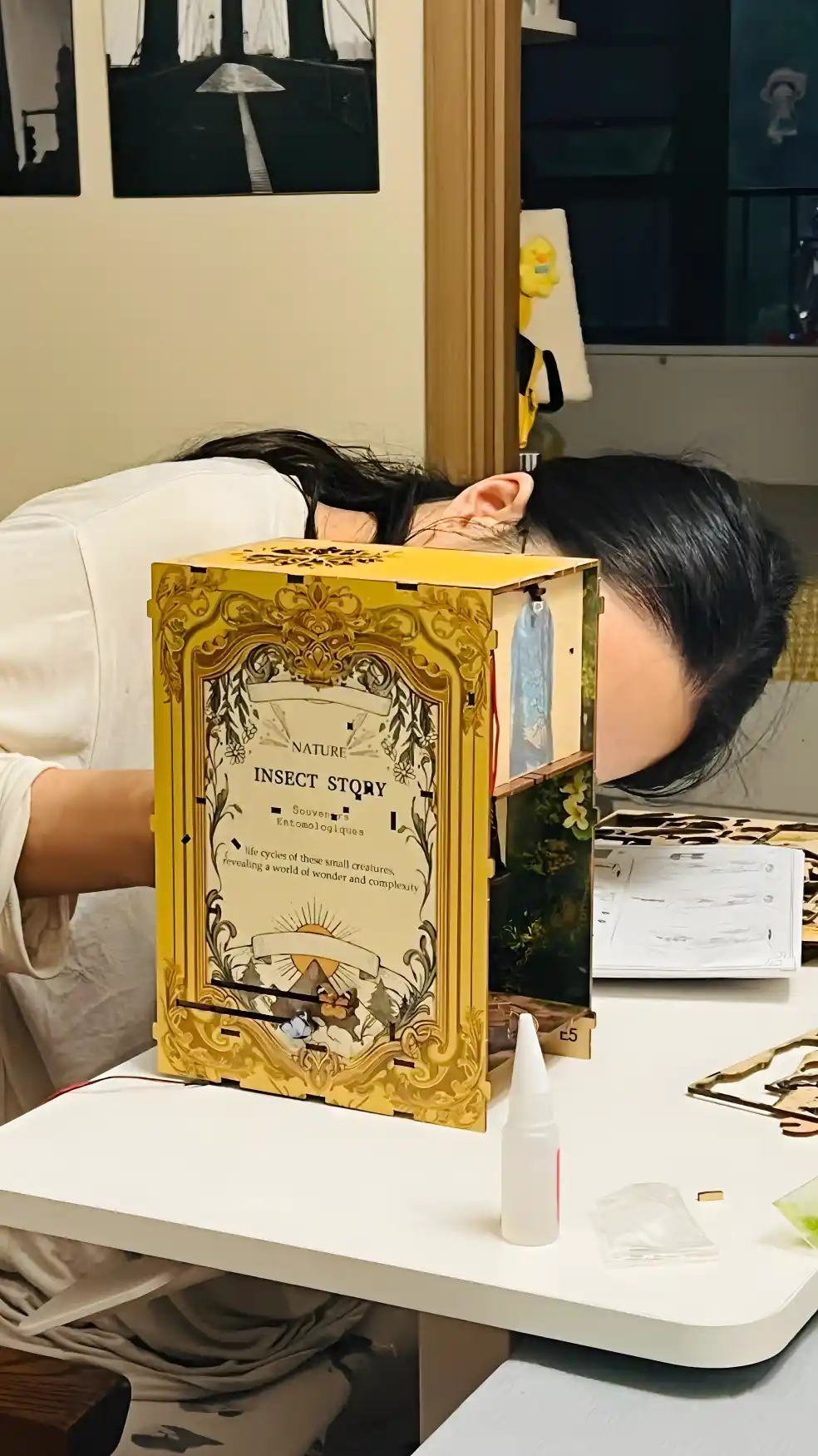 how to make a book nook - Person building "Insect Story" book nook kit, showing golden facade.