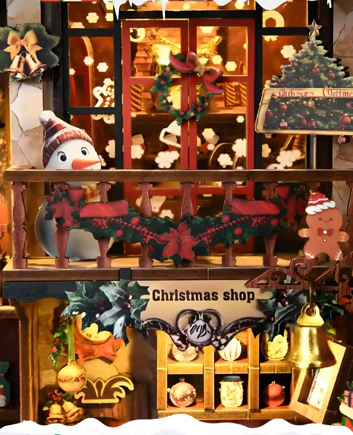 Close-up of the Christmas Shop DIY Book Nook Kit's exterior and upper level with a snowman, garlands, and a gingerbread man.