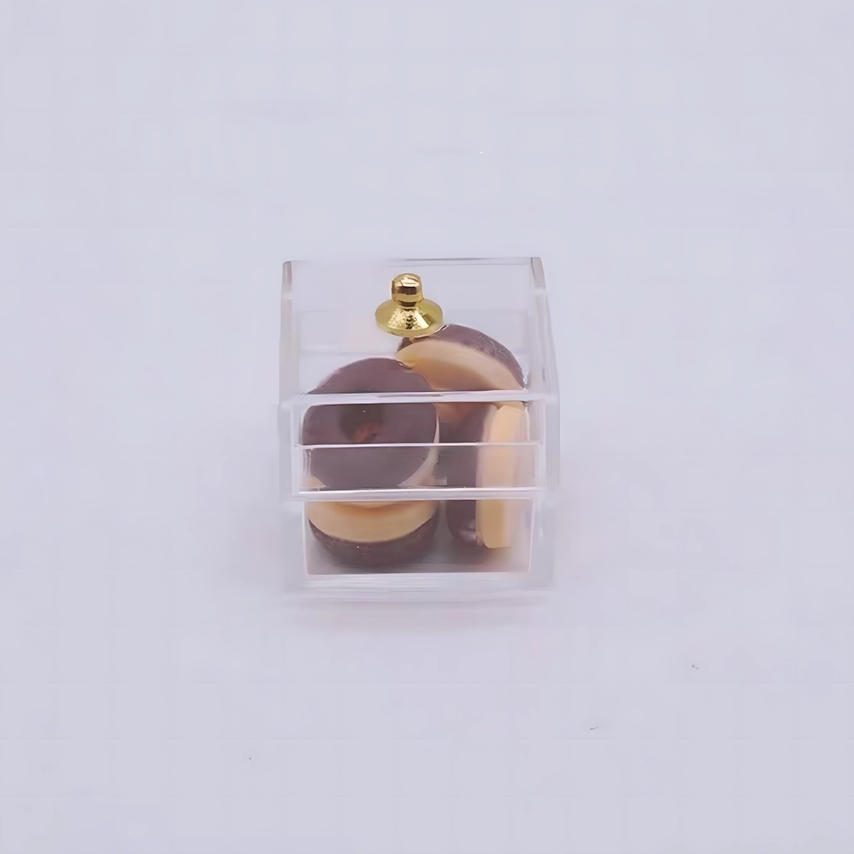 A small, clear plastic box containing tiny brown and cream miniature donuts.