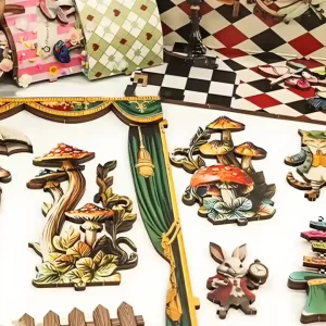 Detailed view of flat, colorful wooden pieces for a book nook kit, showing a rabbit in a suit, various mushrooms, and playing card designs.
