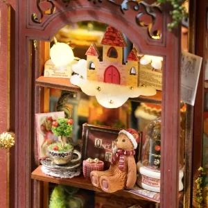 A macro shot of the dollhouse window display, showing a teddy bear with a red and white scarf, a small decorative castle on a cloud, and a snow globe.