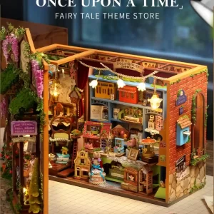 A view of the fully built Fairy Tale Kingdom Dollhouse Shop, showing the exterior brick wall, a sign for "Angel Street," and the lighted interior filled with tiny shops.