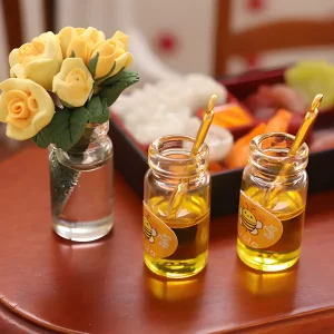 Dollhouse candy jar, Mini candy container, two honey jars, bee stickers, miniature yellow roses in vase, tiny sushi set in background.