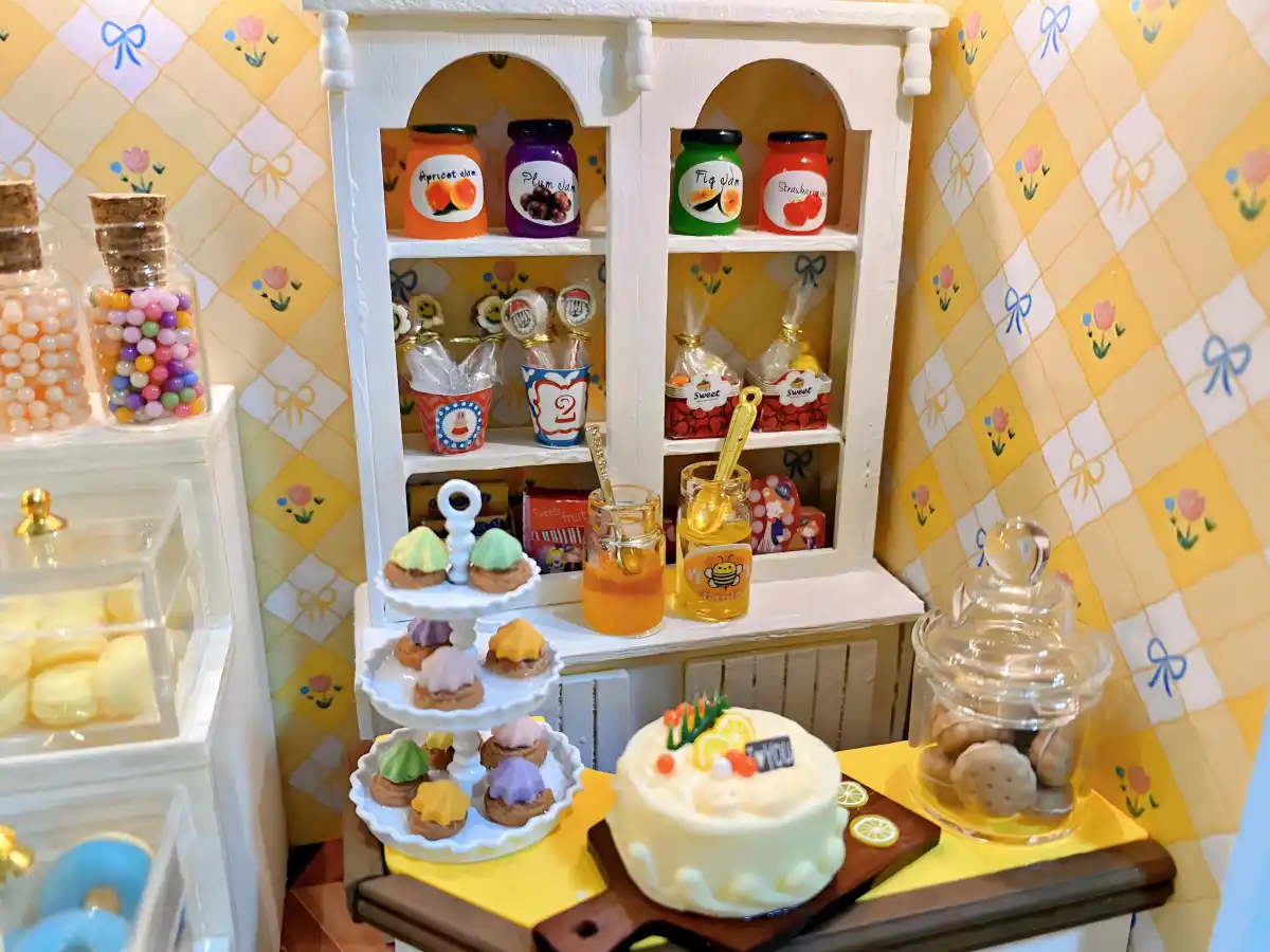 Miniature dessert cabinet, tiered cake stand, candy jars, DIY miniature dollhouse makeover, dollhouse customization ideas.