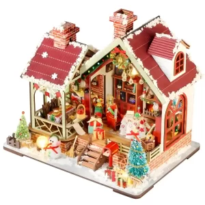 Assembled Warm Christmas Lodge miniature house with lights, a snowy ground, a snowman, and Christmas decor.