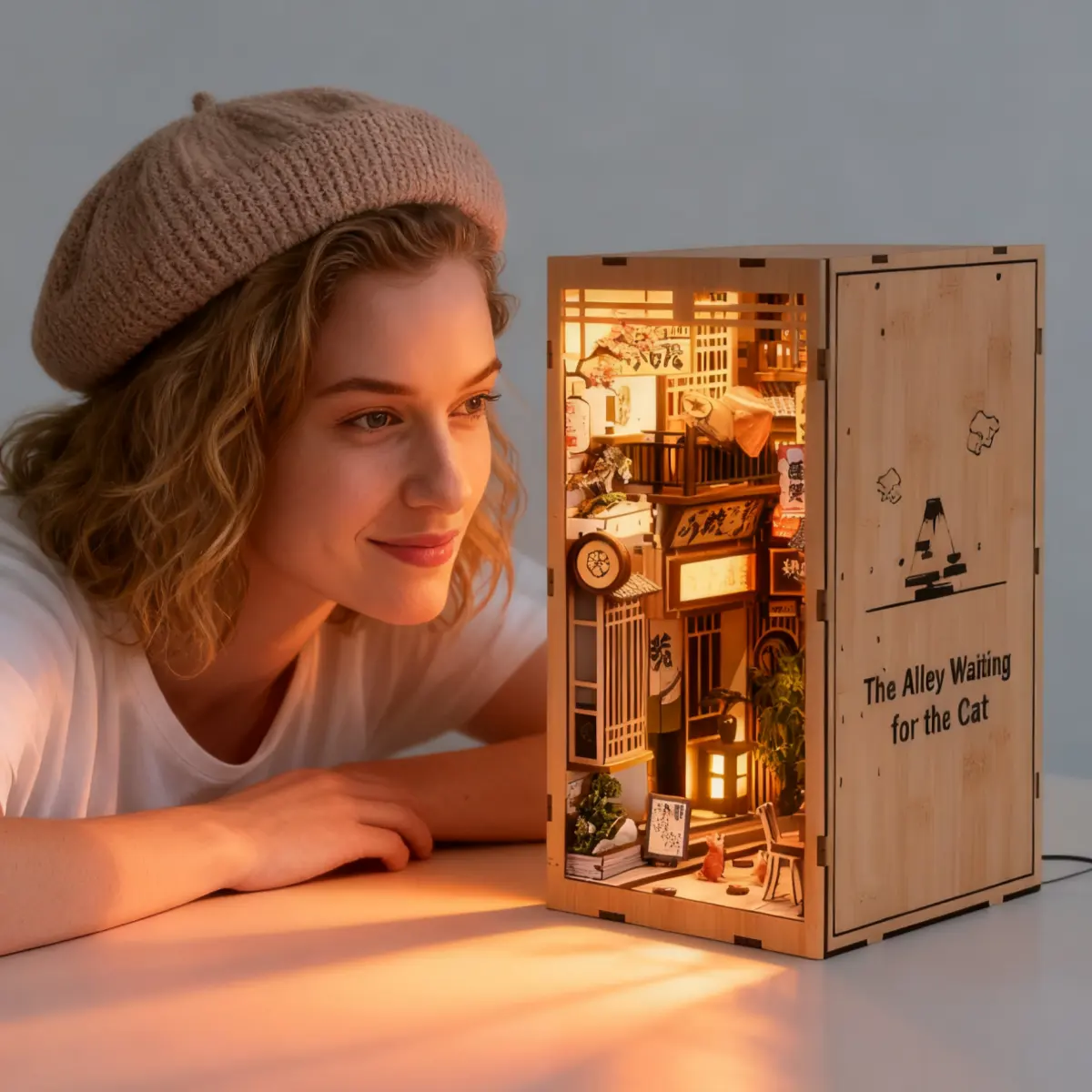 Girl with beret looking at a lit-up book nook therapy miniature kit.