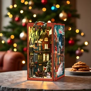 Christmas Street Corner book nook glowing on a desk, with a decorated tree in the background.