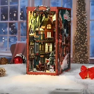 Side view of a lighted Christmas Lane book nook on a snowy surface.
