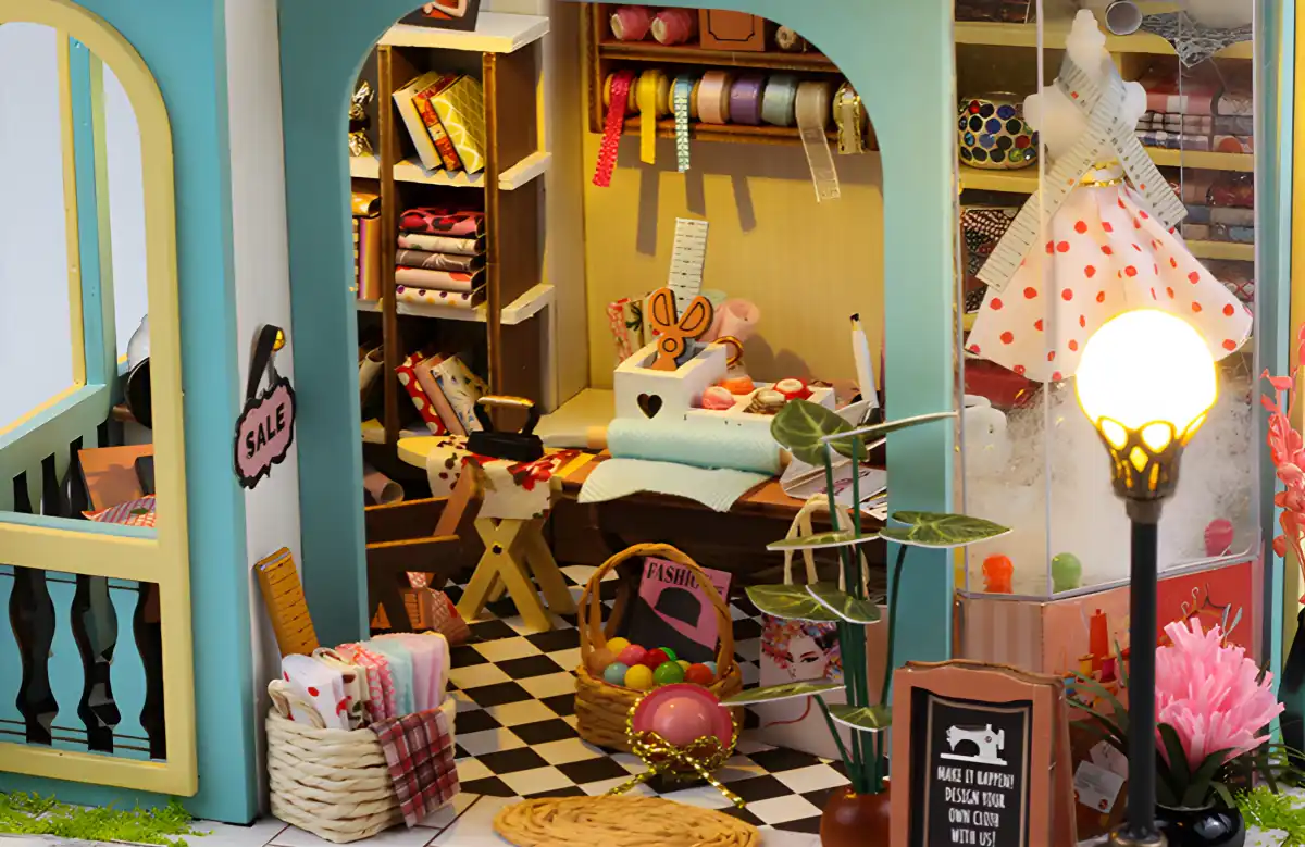 Miniature Tailor Shop dollhouse doorway view, cozy slow-living interior, handmade DIY craft kit.