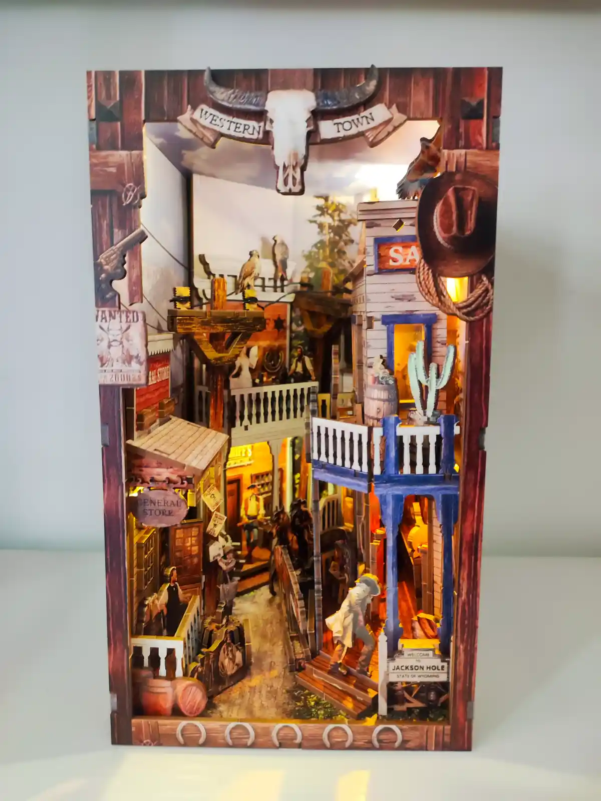 Fully assembled and illuminated Western Town Book Nook, a detailed DIY western miniature kit.
