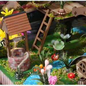 Close-up of a well in a decorative dollhouse, surrounded by natural landscapes.