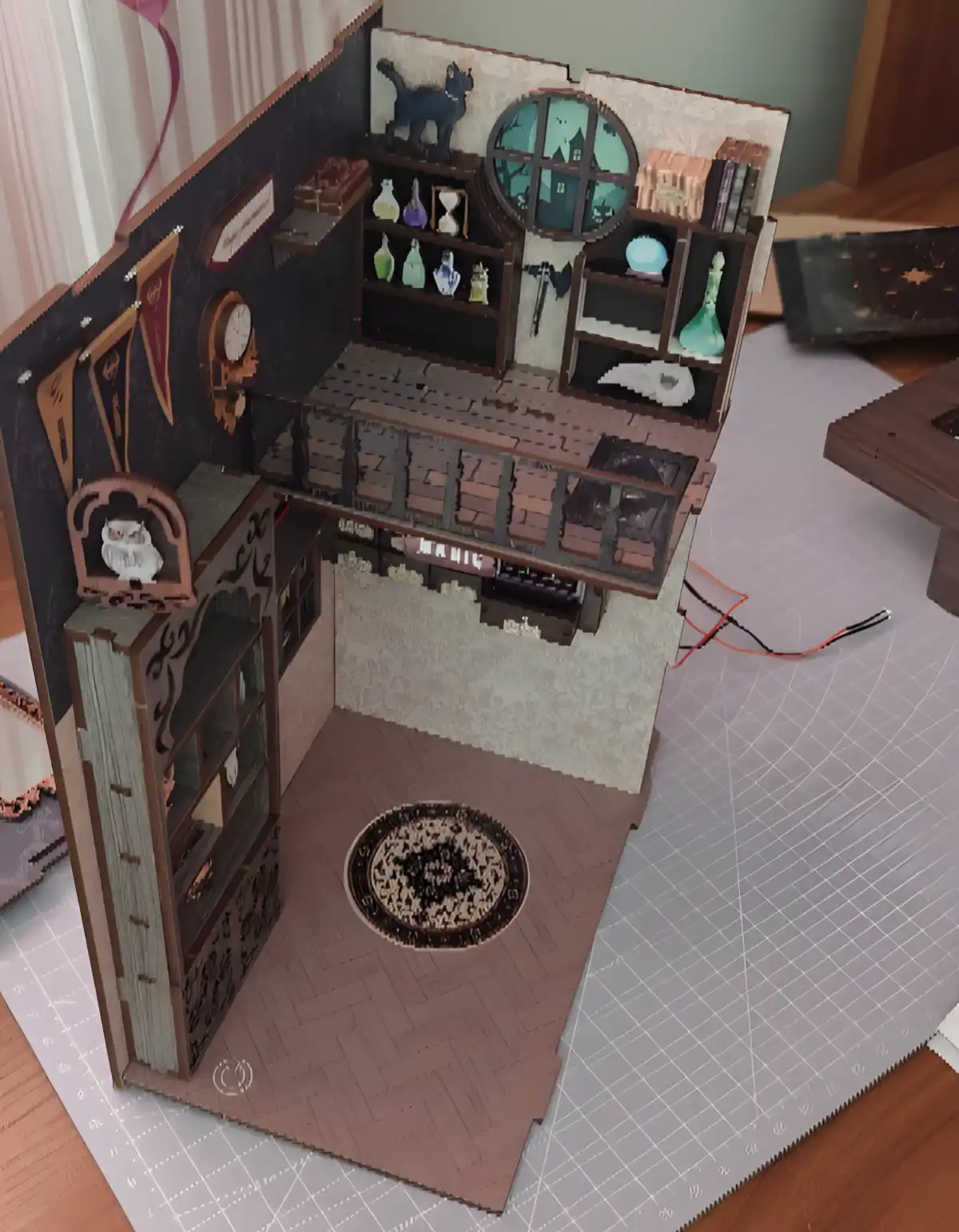 Assembling a bookshelf diorama, showing the wooden walls and floors.