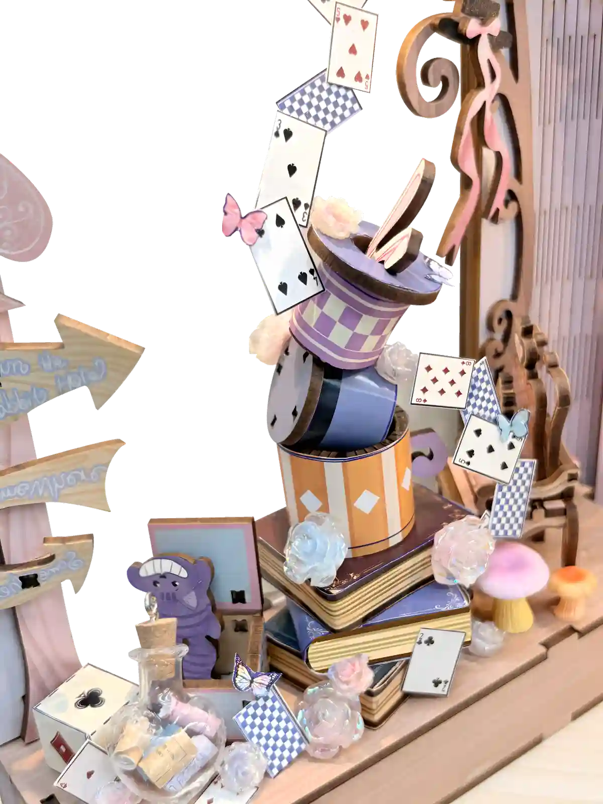 Mad Hatter and Cheshire Cat details in a whimsical Alice in Wonderland bookshelf insert with playing cards.