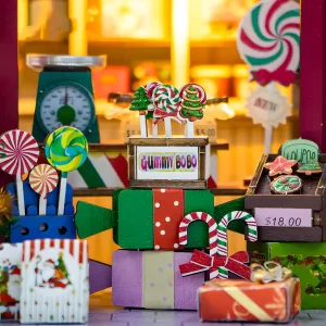 Detailed candy shop miniature counter with lollipops, cookies, candy canes, and a vintage scale.