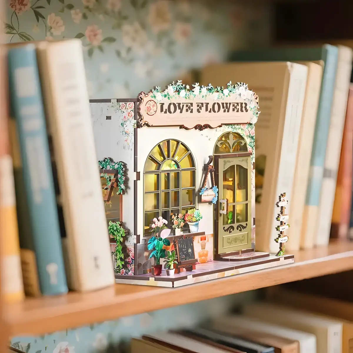 Love Flower Shop DIY Book Nook Kit displayed on a bookshelf, a charming miniature flower shop.