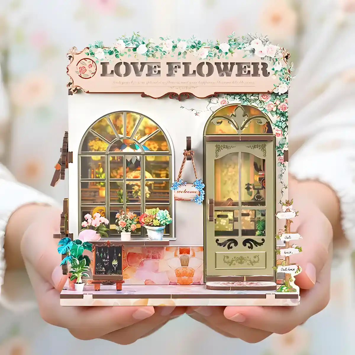 A person holding the completed Love Flower Shop DIY Book Nook, a perfect healing gift.