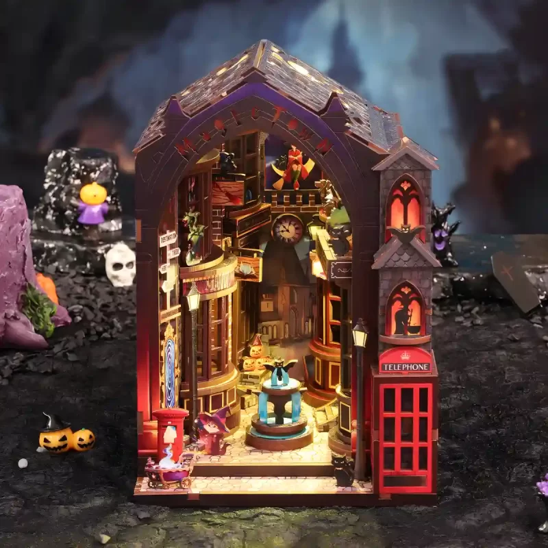 A front view of the illuminated Magic Alley DIY Book Nook Kit, showcasing the detailed secret alley with its charming wizard shops and fountain.