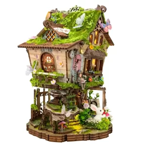 Side view of Rowan’s Treehouse Miniature House DIY Kit, illuminated whimsical woodland dollhouse display.