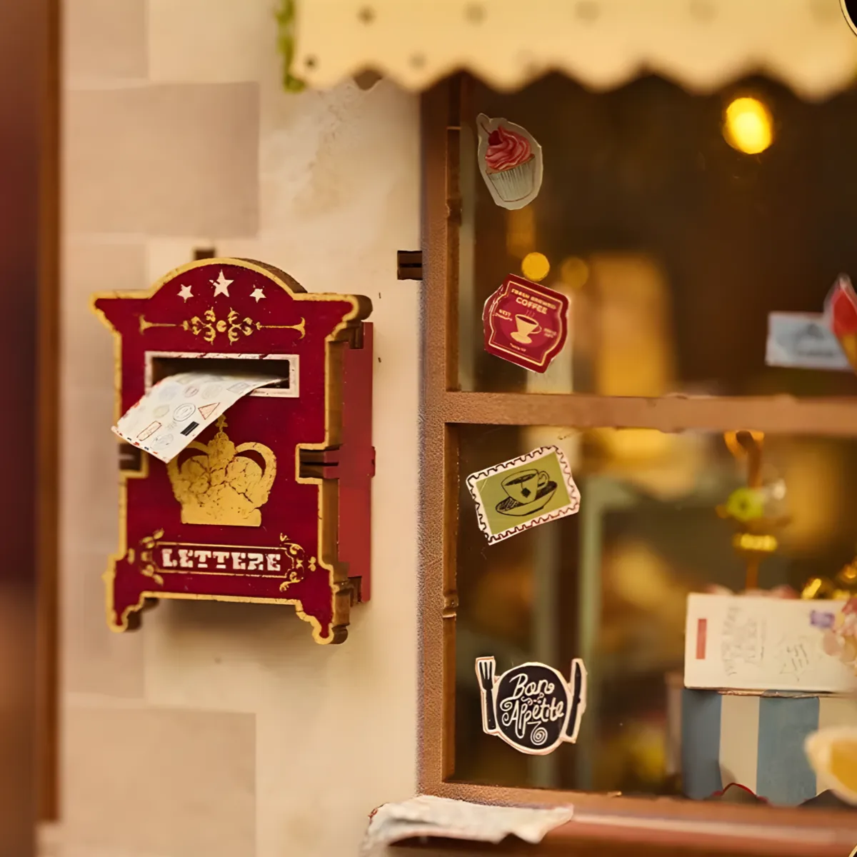 Miniature red mailbox detail, The Dainty Steeper book nook, with window stickers and crown.