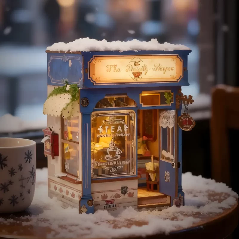 The Dainty Steeper book nook kit, snowy English vintage tea shop, illuminated storefront, tabletop.