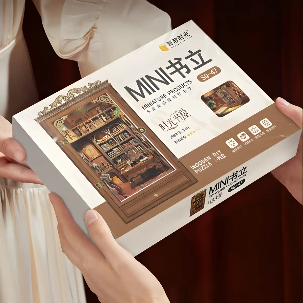 A person holding the Time Book House DIY Book Nook Kit gift box, an ideal book lovers gift.