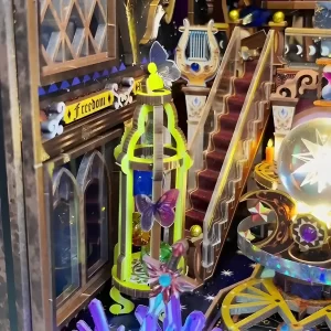 Close-up on the Zodiac Fantasy book nook's butterfly cage, staircase, and Freedom sign; a detailed Fantasy DIY Book Nook.