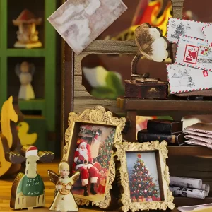 Miniature decor: framed photos of Santa, tiny letters, and gold angel, great Holiday book nook.