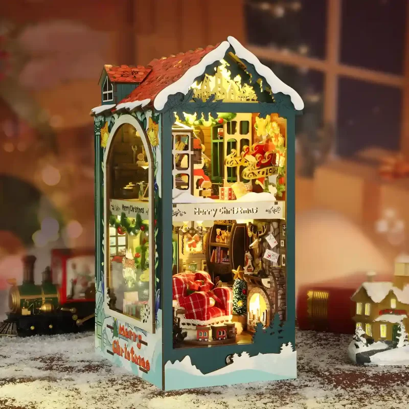 Complete illuminated Merry Christmas book nook; two-story interior with armchair and train.