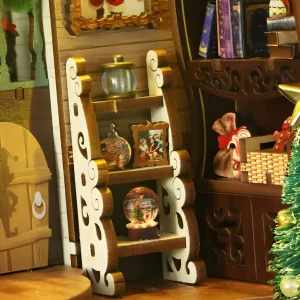 Tiered white shelf with snow globe and framed miniature picture in Holiday book nook.