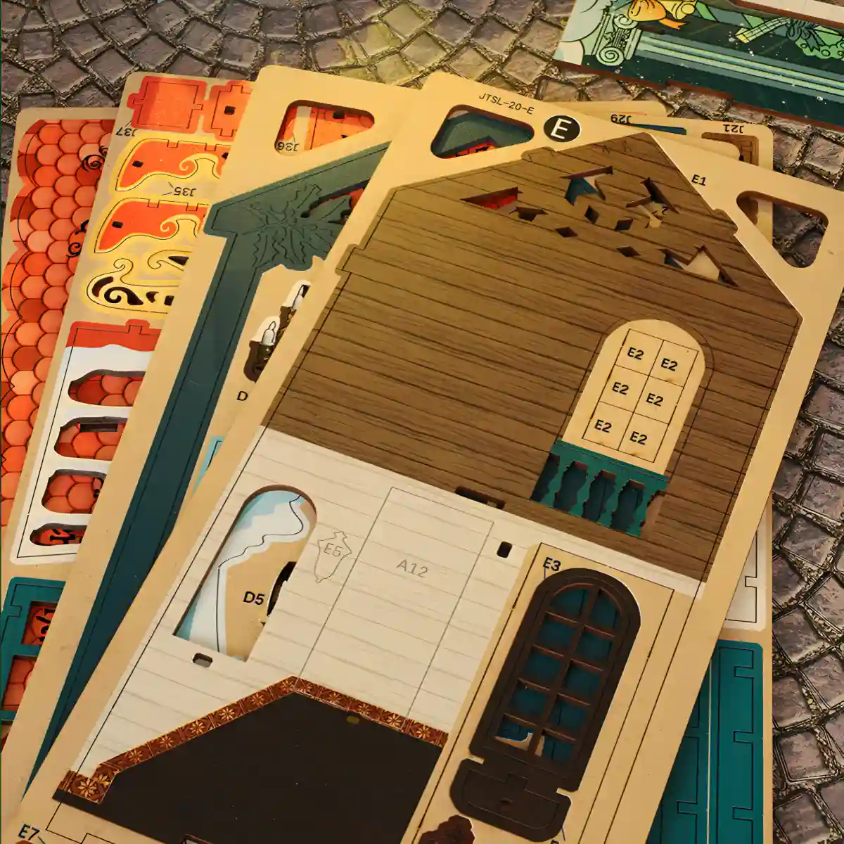 Pre-cut wooden punch-out sheets for assembly of the Merry Christmas DIY Book Nook Kit.