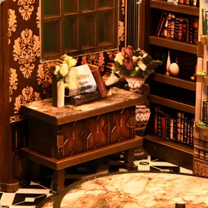 Vintage miniature wooden chest, window, and floral decorations inside the Wisdom Rings Bookstore book nook.
