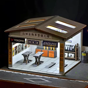 Illuminated Yamada Auto Repair Garage Miniature House at night, interior lighting display.