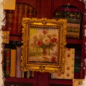 Miniature golden-framed flower painting inside the Art Bookstore book nook shelving unit.