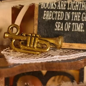 Miniature gold trumpet detail beside a quote sign inside the Bookstore Book Nook display.