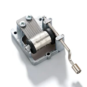 Side view of silver crank music box mechanism showing handle length and worm gear assembly.