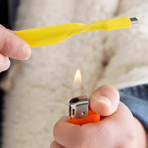 Using a lighter to apply heat to a yellow heat shrink tube for cable repair.