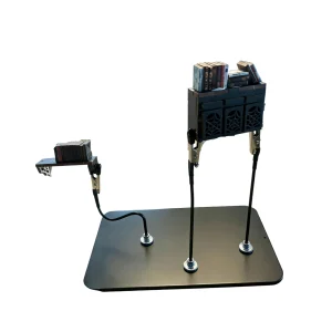 Model spray painting stand holding miniature book nook components for hands-free hobby assembly.
