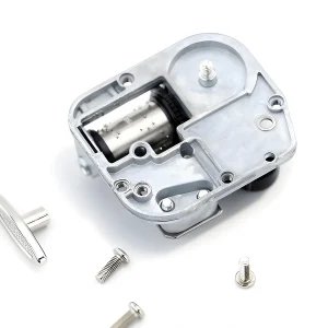 Wind up music box mechanism kit with mounting screws and removable winding key for DIY crafts.
