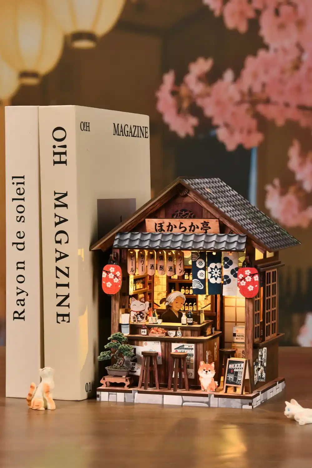 Miniature Japanese pub bookshelf diorama on a desk with books and cats