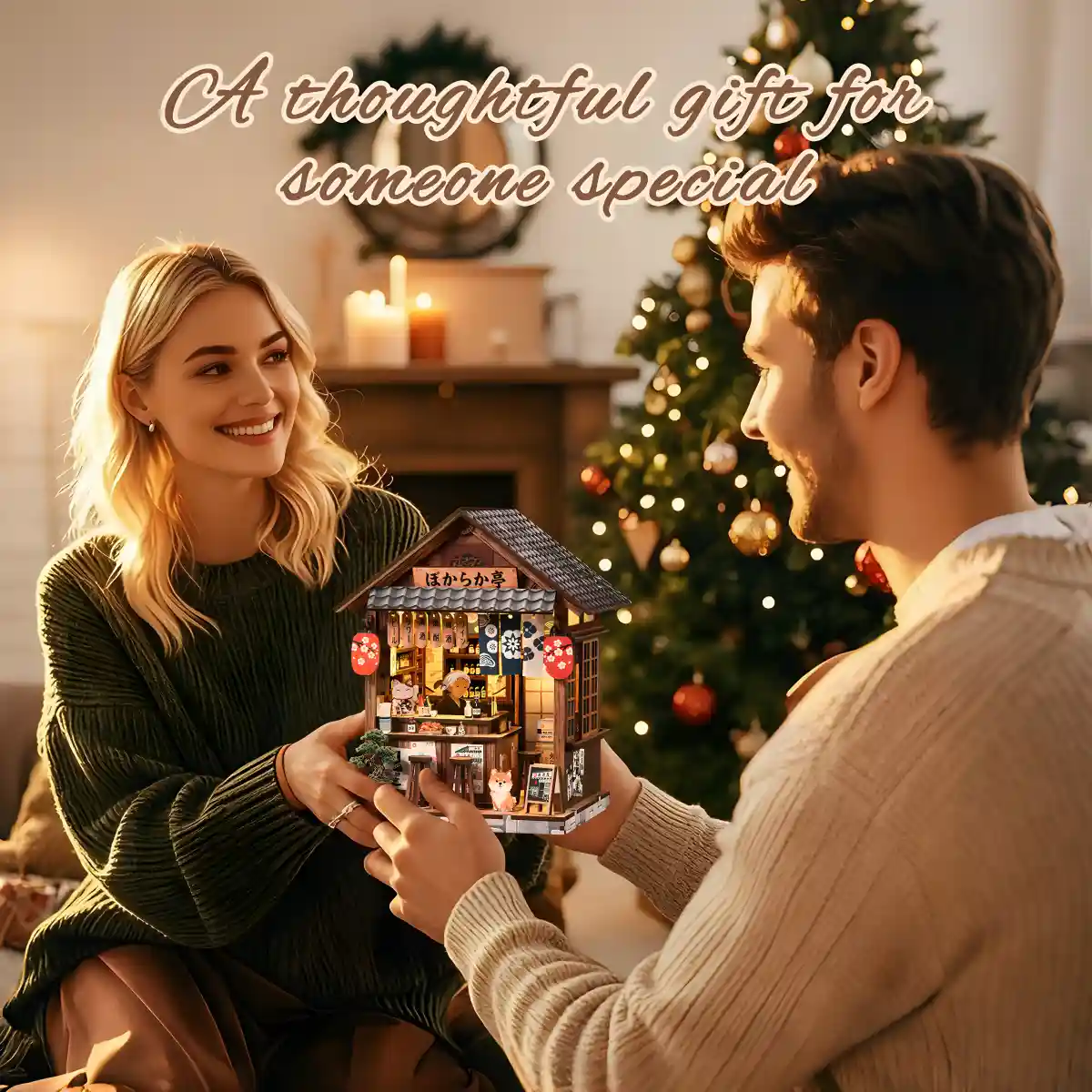 Couple holding miniature Japanese Book Nook kit under Christmas tree