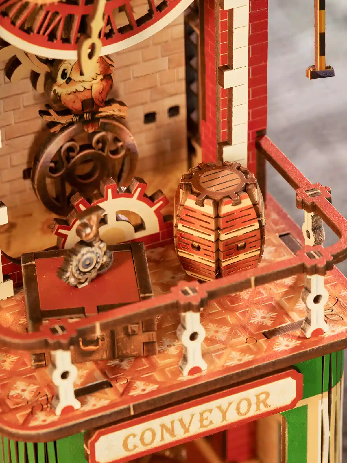 Moving gear wooden puzzle detailing a miniature wooden barrel and mechanical clock tower balcony.